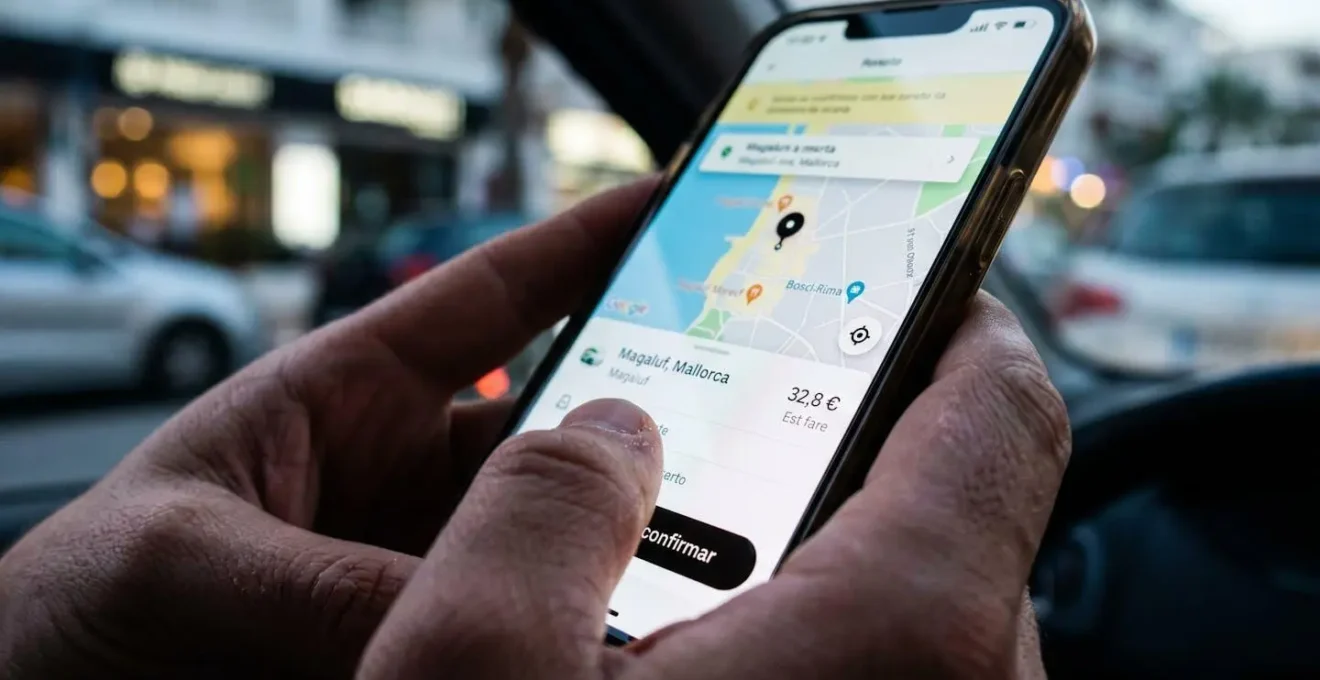 Smartphone-Bildschirm zeigt Taxi-App mit Fahrpreis-Schätzung und Kartenansicht Magaluf